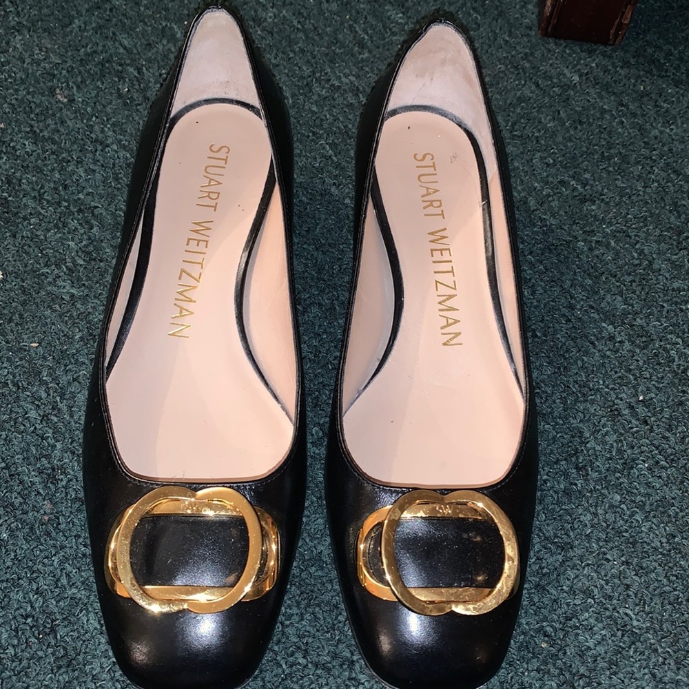 Black heeled shoes with gold buckle on top